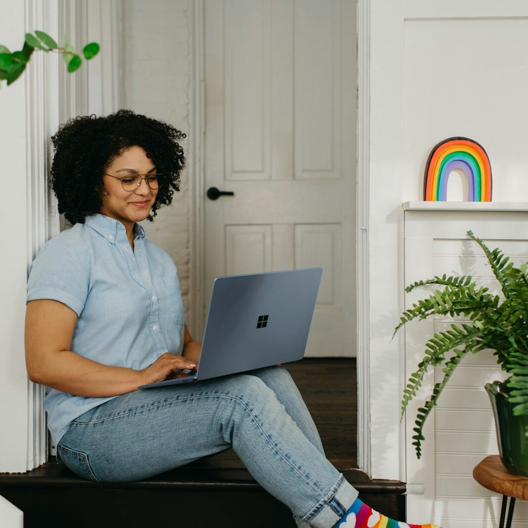 a woman sitting on the floor using a laptop